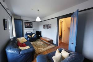 ein Wohnzimmer mit 2 blauen Sofas und einem Tisch in der Unterkunft Townhouse 34 in Derry Londonderry