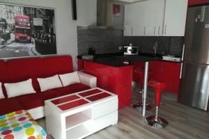 a kitchen with red and white cabinets and a red couch at Apartamento en ribeira sacra. Chantada in Chantada