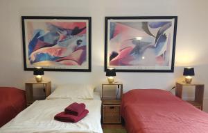 1 Schlafzimmer mit 2 Betten und 2 Bildern an der Wand in der Unterkunft Ferienwohnung Rheinblick Koblenz in Koblenz