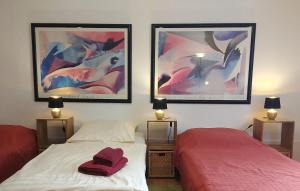1 dormitorio con 2 camas y 2 cuadros en la pared en Ferienwohnung Rheinblick Koblenz, en Coblenza