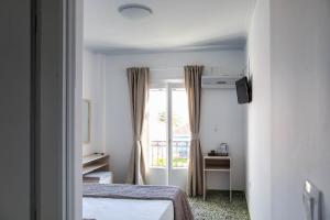 a bedroom with a bed and a window at Argonaftis Spetses in Spetses +15 photos