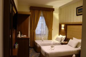 a hotel room with two beds and a window at Diyar Taiba Hotel in Medina