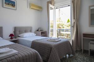 a hotel room with two beds and a balcony at Argonaftis Spetses in Spetses