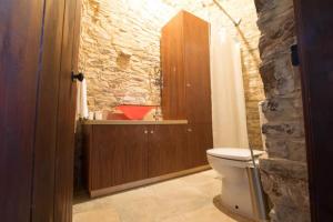 a bathroom with a white toilet and a stone wall at Whitestone Mill in Pano Lefkara