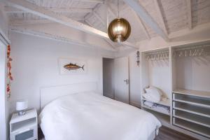 a white bedroom with a white bed and a ceiling at Monchique Islet View House T2 in Faja Grande