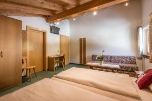 1 dormitorio con cama, sofá y mesa en Ciasa Roch, en Corvara in Badia