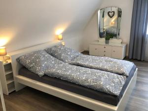a bed in a bedroom with a mirror and lights at Haus Blum in Weisweil