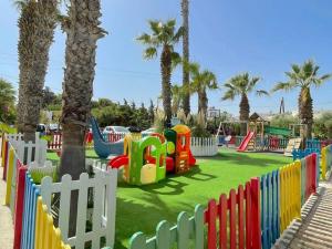 einen Spielplatz mit einem bunten Park mit Palmen in der Unterkunft Minoa Apartments in Ammoudara