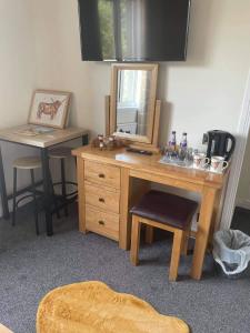 a wooden desk with a mirror and a stool at Haste Ye Back in Inverness