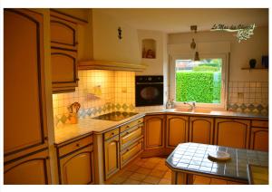 een keuken met een wastafel en een raam bij Le Mas des Oliviers in Bouillon