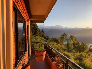 a balcony with a table and a plant on it at Superview Lodge Sarangkot in Pokhara