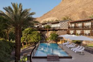 a hotel with a swimming pool and palm trees at Herbert Samuel Royal Shangri-La Eilat in Eilat