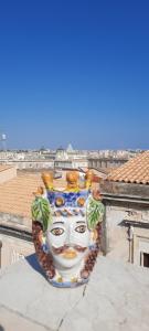 a vase with a face on top of a building at La Terrazza di Apollo al centro di Ortigia in Siracusa