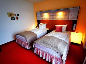 Postel nebo postele na pokoji v ubytování Tante ALMA's Mannheimer Hotel