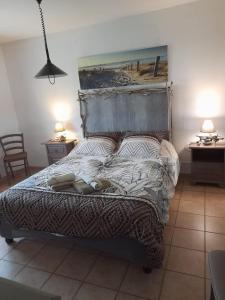 un letto in una camera da letto con due tavoli e due lampade di chambre les flamants vue sur les étangs petit déjeuner compris a Saintes-Maries-de-la-Mer