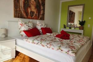 duże łóżko z czerwono-białymi poduszkami w obiekcie Moderne Ferienwohnung direkt am Bodensee w mieście Überlingen