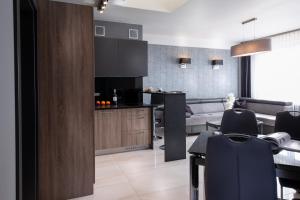 a kitchen and living room with a table and chairs at Aparthotel New Lux in Wrocław