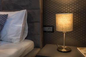 a lamp sitting on a table next to a bed at Aparthotel New Lux in Wrocław