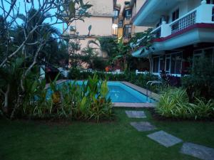 a swimming pool in a yard next to a building at River side apartment in Cavelossim