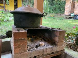 una olla en la parte superior de un horno de ladrillo en Chalé Hakuna Matata, en Lumiar