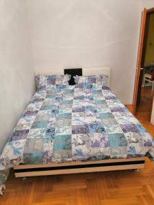 Una cama con edredón en un dormitorio en Milgor, en Banja Luka