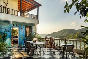 Un balcón con mesas y sillas y vistas al océano. en Casa Blanca - Taganga, en Santa Marta