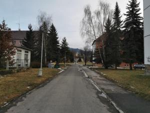 an empty street in a town with houses and trees at Flat in the Heart of Liptovsky Mikulas in Liptovský Mikuláš