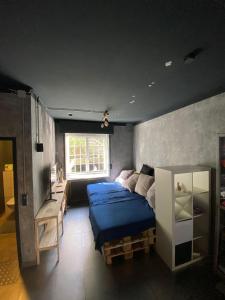 Un dormitorio con una cama azul y una ventana en Jonnys Loft, en Osnabrück
