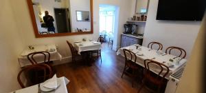 un comedor con 2 mesas y un espejo en Colebrook Guest House en Farnborough