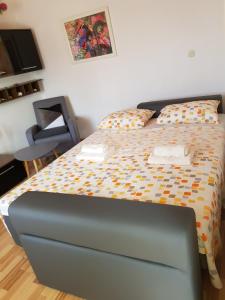 Cette chambre comprend un grand lit et une chaise. dans l'établissement Bugenvilija apartment, à Šibenik