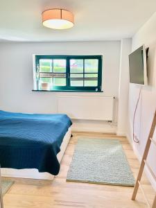 a bedroom with a blue bed and a window at Top Ferienwohnung im Herzen Reriks mit Garten in Rerik