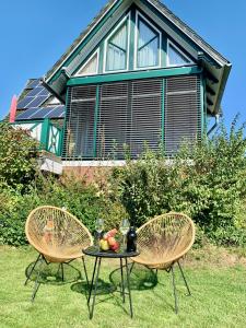 2 chaises et une table en face d'une maison dans l'établissement Top Ferienwohnung im Herzen Reriks mit Garten, à Rerik