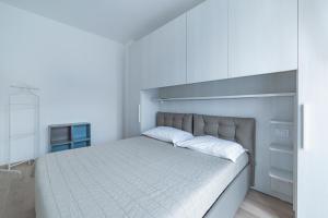 Biała sypialnia z dużym łóżkiem i białymi szafkami w obiekcie Milano Cosy APT with Balcony! w Mediolanie