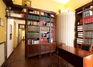 a library with wooden book shelves filled with books at Le stanze di Bianca in Palermo