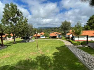 a green yard with houses and trees in the background at Cabañas Mazzatl 6 pax in Mazamitla