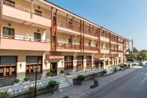 an apartment building with balconies on a street at Famissi Hotel in Kalabaka