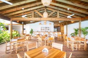 a restaurant with wooden tables and chairs at Naboo Resort & Dive Center - Adults Only in West Bay