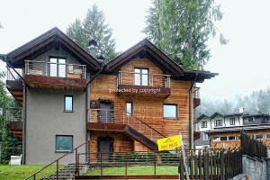 Una casa con un cartel en el frente en Campiglio Luxury Apartment with SPA, en Madonna di Campiglio
