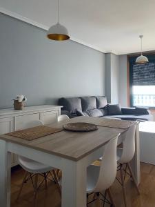 雷東德拉的住宿－A CASA DO PEREGRINO，一间带桌子和白色椅子的用餐室