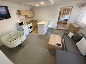 a living room with a couch and a table and a kitchen at ARD Apartments - Levice in Levice