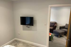 TV de pantalla plana en la pared de la sala de estar en New apartment within short walk of the beach, en Southbourne