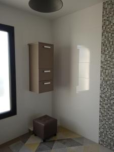 Un rincón de una habitación con un armario y un taburete. en Chambres d'hôtes dans maison contemporaine, en Vernouillet 12 fotos más