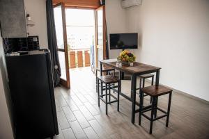 a kitchen with a table and chairs and a refrigerator at CS LUXURY HOUSE in Lido di Ostia