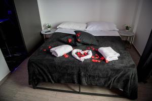 a bed with towels and red flowers on it at CS LUXURY HOUSE in Lido di Ostia