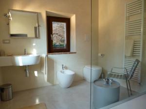 un bagno con lavandino, WC e specchio di Holiday Apartment in Historical Palace a Montepulciano