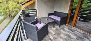 a porch with chairs and a table on a balcony at Comfort Home Apartment 3 in Petroşani +3 photos
