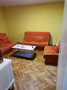 uma sala de estar com dois sofás e uma mesa de centro em Kuca za odmor Simic em Vrnjačka Banja