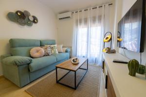 a living room with a blue couch and a table at Apartamento Boutique Plasencia Centro in Plasencia