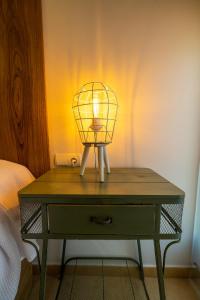 een lamp op een tafel naast een bed bij Apartamento Boutique Plasencia Centro in Plasencia