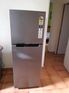a stainless steel refrigerator sitting in a kitchen at Palm Grove 1 Bhk Apartment at Candolim Beach with free Wifi in Candolim